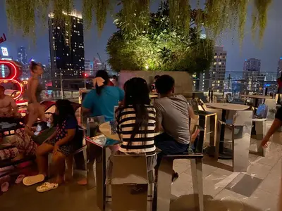 a group of people sitting at tables on a rooftop at Staybliss At Ceylonz Suites in Kuala Lumpur