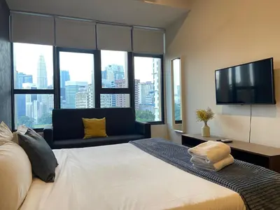 a bedroom with a large bed and a television at Staybliss At Ceylonz Suites in Kuala Lumpur