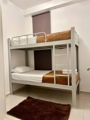 two bunk beds in a room with a rug at Legasi High floor 3 BR KLCC view in Kuala Lumpur