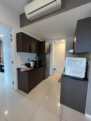 a kitchen with brown cabinets and a white tile floor at Apartment at Robertson by Wgshomestay in Kuala Lumpur