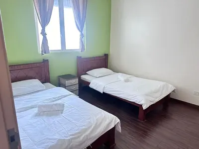 two twin beds in a room with a window at Ubays Zetepark House in Kuala Lumpur