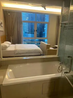 a bathroom with a tub and a bed and a mirror at Luxzell suit KlCC-7minutes walk to KLCC in Kuala Lumpur