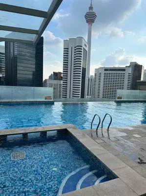 a large swimming pool with a view of a city at Luxzell suit KlCC-7minutes walk to KLCC in Kuala Lumpur
