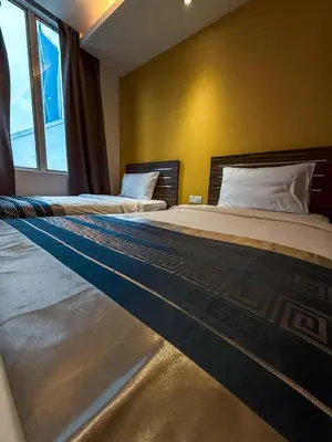 two beds in a room with a window at Hotel 1915 Chinatown Kuala Lumpur in Kuala Lumpur