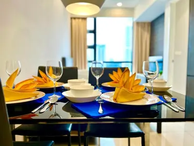a dining room table with plates and wine glasses at The Royal Reside in Kuala Lumpur