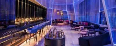 a room with a bar with tables and chairs at Tropicana The Residences by uBook in Kuala Lumpur