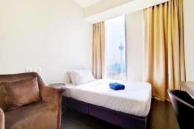 a room with a bed and a couch and a window at Tropicana The Residences by uBook in Kuala Lumpur