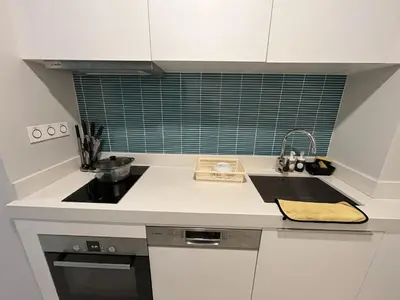 a white kitchen with a sink and a counter top at Tropicana The Residences by uBook in Kuala Lumpur