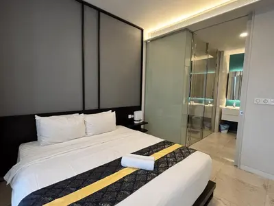 a bedroom with a large bed and a glass door at Tropicana The Residences by uBook in Kuala Lumpur