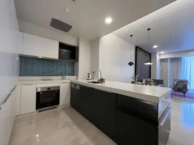 a kitchen with black and white cabinets and a sink at Tropicana The Residences by uBook in Kuala Lumpur