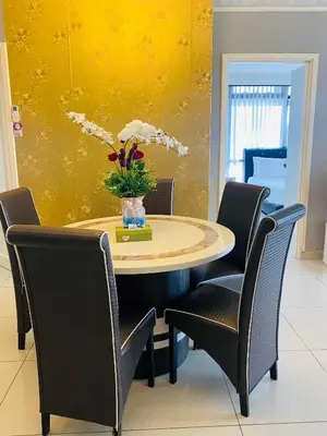 a dining room table with chairs and a yellow wall at 1 Imbi Suites Times Square Bukit Bintang KL in Kuala Lumpur