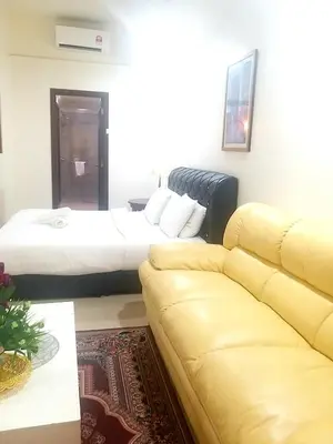 a hotel room with a bed and a couch at 1 Imbi Suites Times Square Bukit Bintang KL in Kuala Lumpur