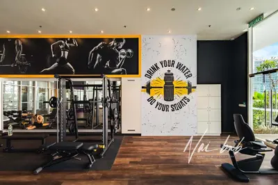 a gym with tread machines and a poster on the wall at NaiBnB in Quill Residences in Kuala Lumpur