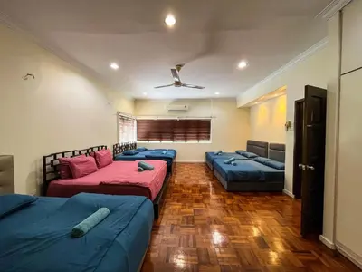 a room with three beds and a couch at Bukit Tunku Grande Villa by uBook in Kuala Lumpur