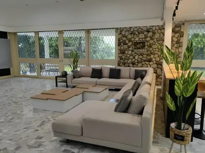 a living room with couches and a stone wall at Bukit Tunku Grande Villa by uBook in Kuala Lumpur