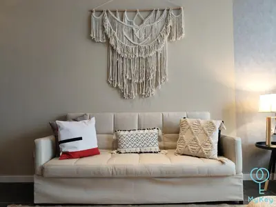 a living room with a white couch with pillows at Scarletz Starlight Suites KLCC in Kuala Lumpur