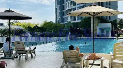 a group of people sitting in chairs by a swimming pool at SG Residence Kuala Lumpur by Fortune Suites in Kuala Lumpur