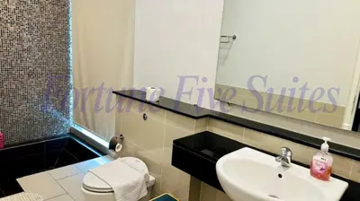 a bathroom with a sink and a toilet and a mirror at SG Residence Kuala Lumpur by Fortune Suites in Kuala Lumpur