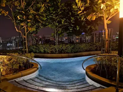a swimming pool at night with a city in the background at Robertson Bukit Bintang in Kuala Lumpur
