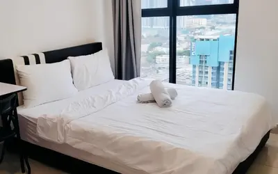 a bed with a white pillow on it with a window at Trion KL Premium Suite in Kuala Lumpur