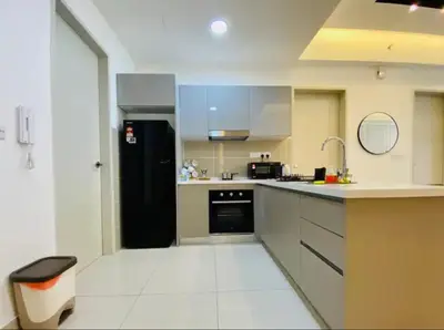 a kitchen with a black refrigerator and white counters at Trion KL Premium Suite in Kuala Lumpur