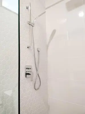 a shower in a bathroom with white tiles at Charming Stay in the Heart of Kuala Lumpur 100Mb in Kuala Lumpur