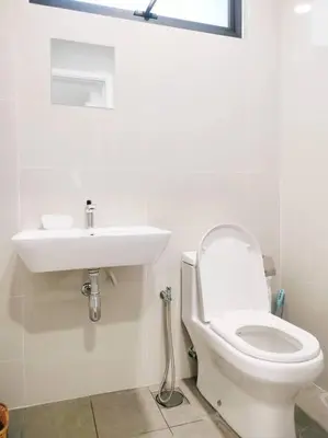 a white bathroom with a toilet and a sink at Charming Stay in the Heart of Kuala Lumpur 100Mb in Kuala Lumpur