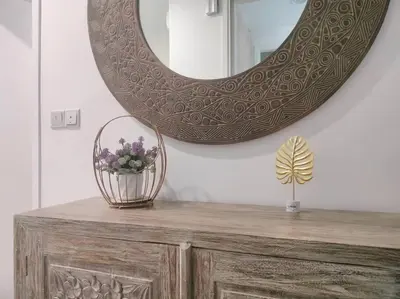 a mirror on top of a dresser with a vase of flowers at Charming Stay in the Heart of Kuala Lumpur 100Mb in Kuala Lumpur