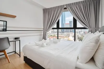 a bedroom with a white bed with a desk and a window at Sleek 3BR Suites Near TRX By Rumabnb in Kuala Lumpur