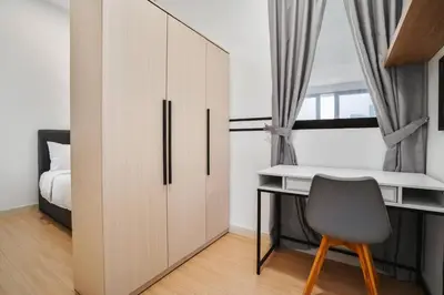 a bedroom with a desk and a bed at Sleek 3BR Suites Near TRX By Rumabnb in Kuala Lumpur
