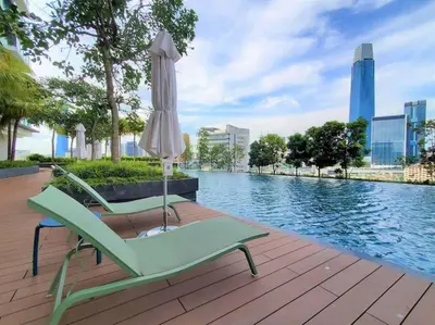 a couple of chairs and an umbrella next to a pool at 2Bedroom near TRX By RumaBnb in Kuala Lumpur