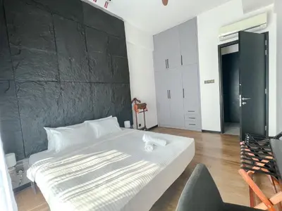 a bedroom with a white bed and a black wall at OPUS Kuala Lumpur by Scape Stay in Kuala Lumpur