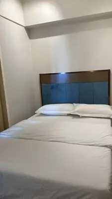 a white bed with a wooden headboard in a room at Star Residence KLCC By M&T in Kuala Lumpur