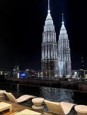 a view of two large towers at night at Star Residence KLCC By M&T in Kuala Lumpur