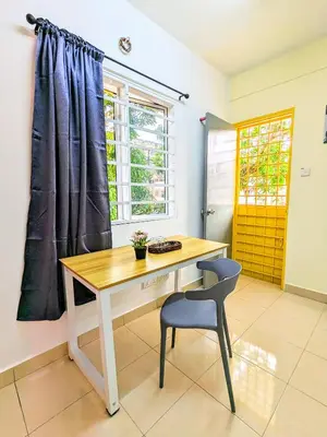 a desk and a chair in a room with a window at Private Room with Bathroom in Kuala Lumpur