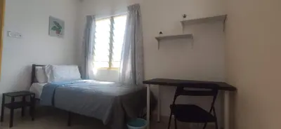 a bedroom with a bed and a table and a window at Hostel Room with Private Bathroom in Kuala Lumpur