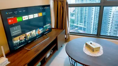 a living room with a tv and a table with a cake at 2-Bed Luxury Resort Robertson in Kuala Lumpur