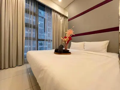 a bedroom with a large bed with a vase of flowers on it at The Robertson-Bukit Bintang by PILLOWTALKS in Kuala Lumpur