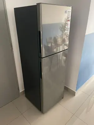 a black refrigerator in a room with a table at M Vertica, Sunway Velocity Kuala Lumpur by Rverse Suite in Kuala Lumpur
