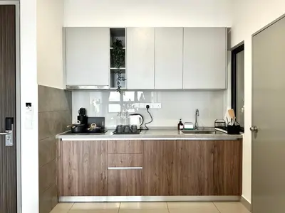 a kitchen with white cabinets and a sink at M Vertica, Sunway Velocity Kuala Lumpur by Rverse Suite in Kuala Lumpur