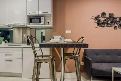 a kitchen with a table with two chairs and a microwave at Summer Suites KLCC by apartx in Kuala Lumpur