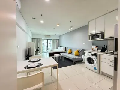 a kitchen and living room with a couch and a table at Summer Suites KLCC by apartx in Kuala Lumpur