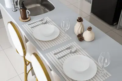 a white table with two plates and glasses on it at Trion Kuala Lumpur in Kuala Lumpur