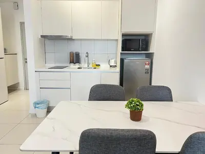 a kitchen with a table and chairs and a refrigerator at Chambers Residence by Gloria Homes in Kuala Lumpur