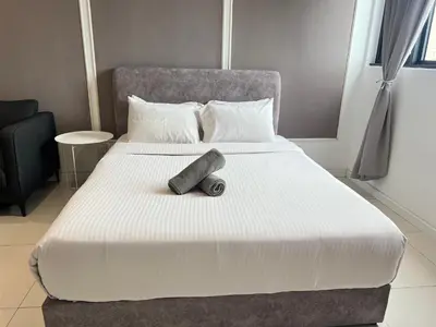 a large bed with a large white comforter with a wooden at Chambers Residence by Gloria Homes in Kuala Lumpur