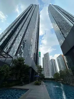 a tall building with a pool in front of a city at Star Resident KLCC By M&T in Kuala Lumpur