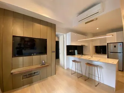 a kitchen with a bar with stools and a television at Star Resident KLCC By M&T in Kuala Lumpur