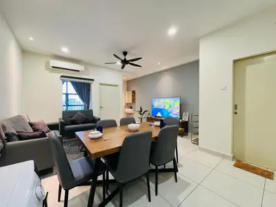 a living room with a wooden table and chairs at Arte Mont Kiara by DeUrban in Kuala Lumpur