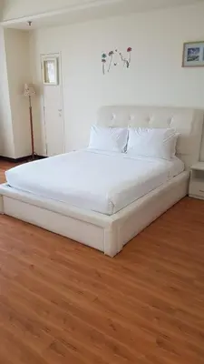a large white bed in a room with a wooden floor at Bukit Bintang Service Suite at Times Square in Kuala Lumpur