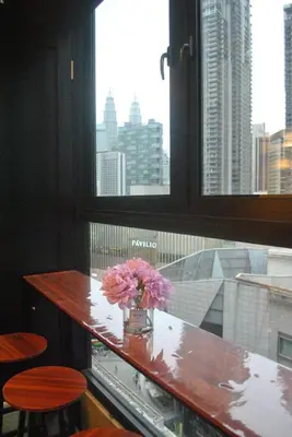 a vase of flowers sitting on a table in a window at Fahrenheit 88 Suites Bukit Bintang C 3R in Kuala Lumpur